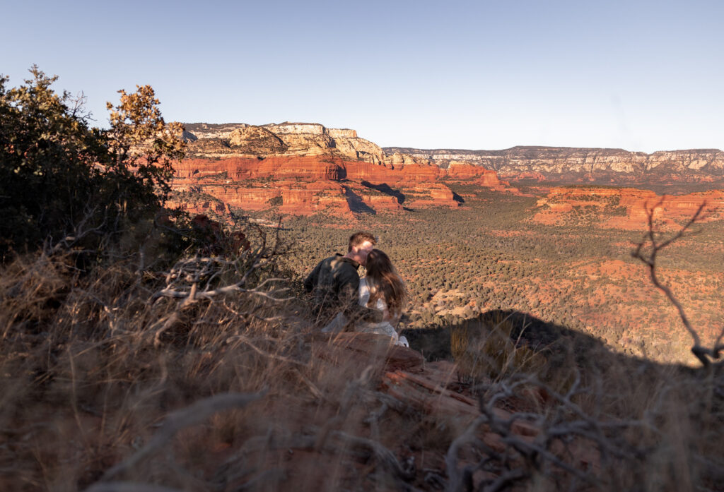 A Sedona Engagement Photo of a couple kiss on the cliff in Sedona, Arizona. Photo taken by Kollar photography Arizona Elopement Photographer. 