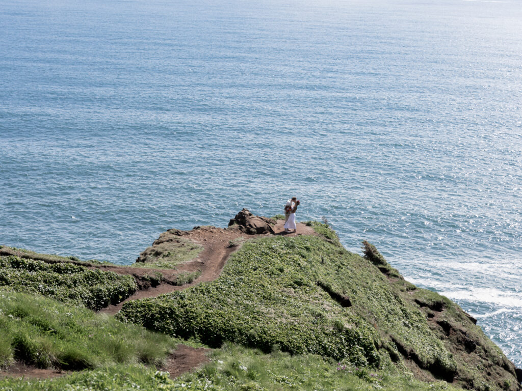 A married couple kissing on a cliff with the ocean in the background. This was taken on the Oregon coast by Kollar photography. Arizona Elopement Photographer 