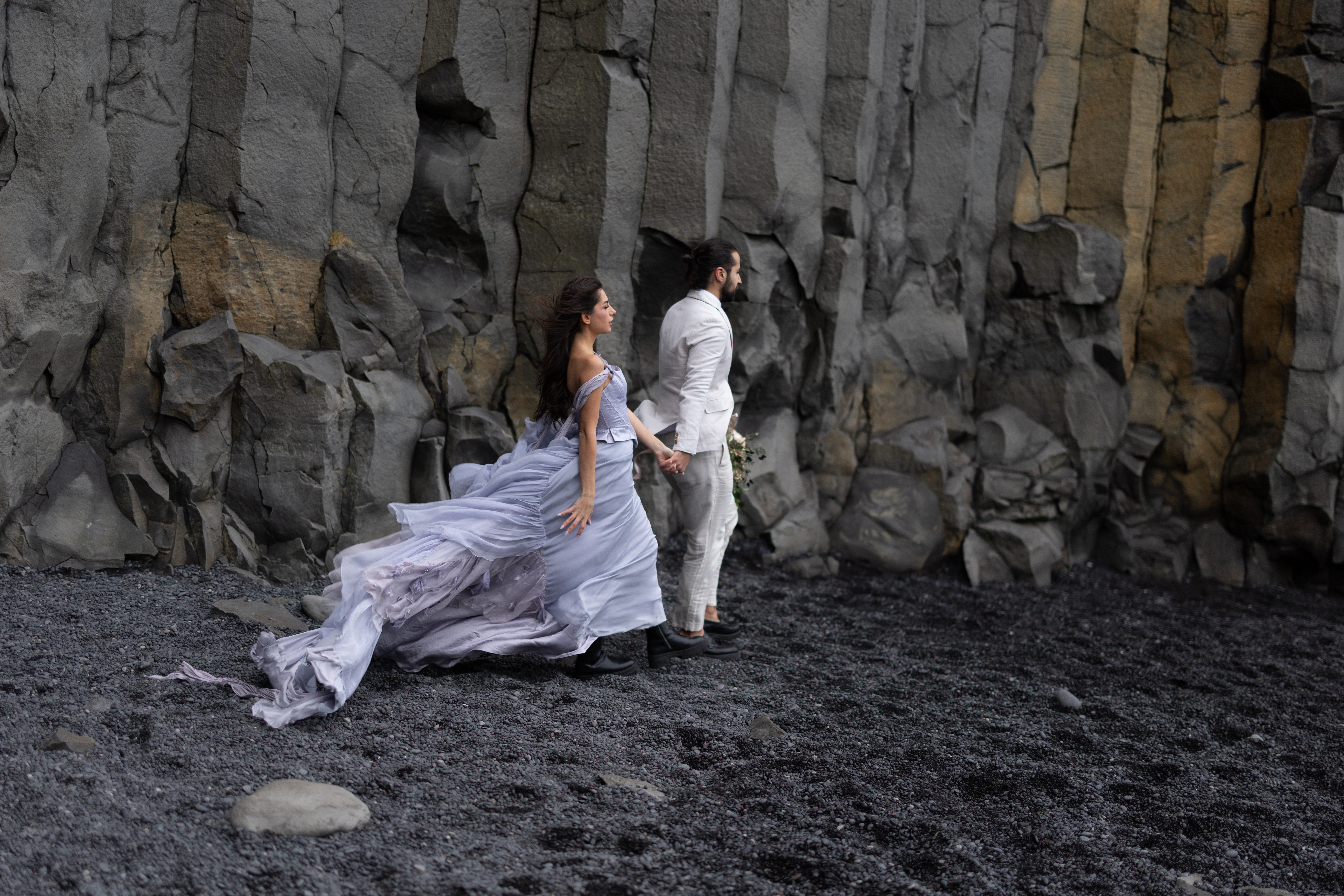 Bride in a flowing wedding dress at Reynisfjara Black Sand Beach in Iceland