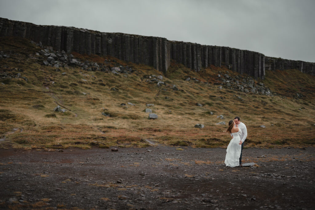 Bride standing near basalt cliffs in South Iceland elopement | Kollar Photography